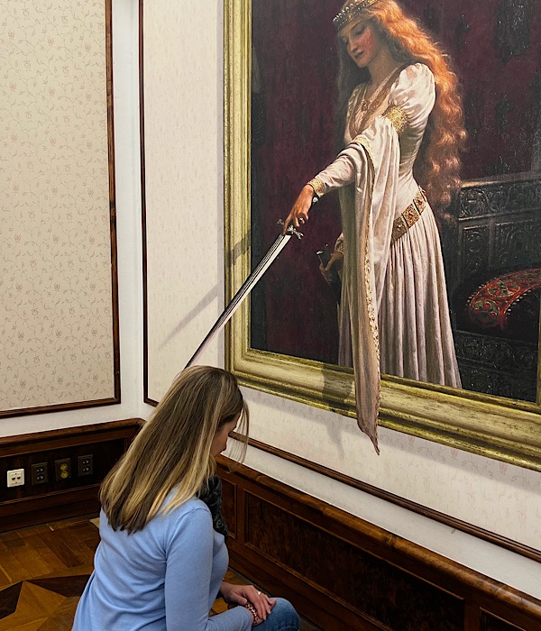 Frau knieend vor Gemälde